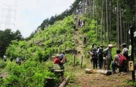 山に登るハイカーや休憩する人で賑わう愛宕山頂上直下の様子