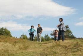 黒指の稜線の草原で登ってきた景色を振り返り堪能するハイカー