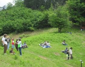 初夏の見晴らしの良い黒指の草原で休憩するハイカー