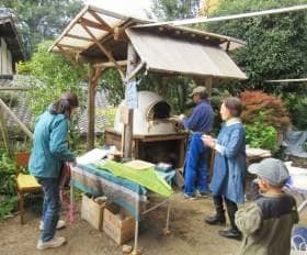 民家の軒先の手作りピザ窯で焼かれるピザ